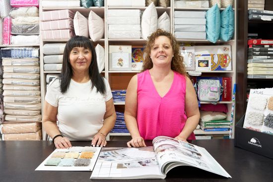 Imagen de las dos trabajadoras de la tienda sonriendo detrás del mostrador