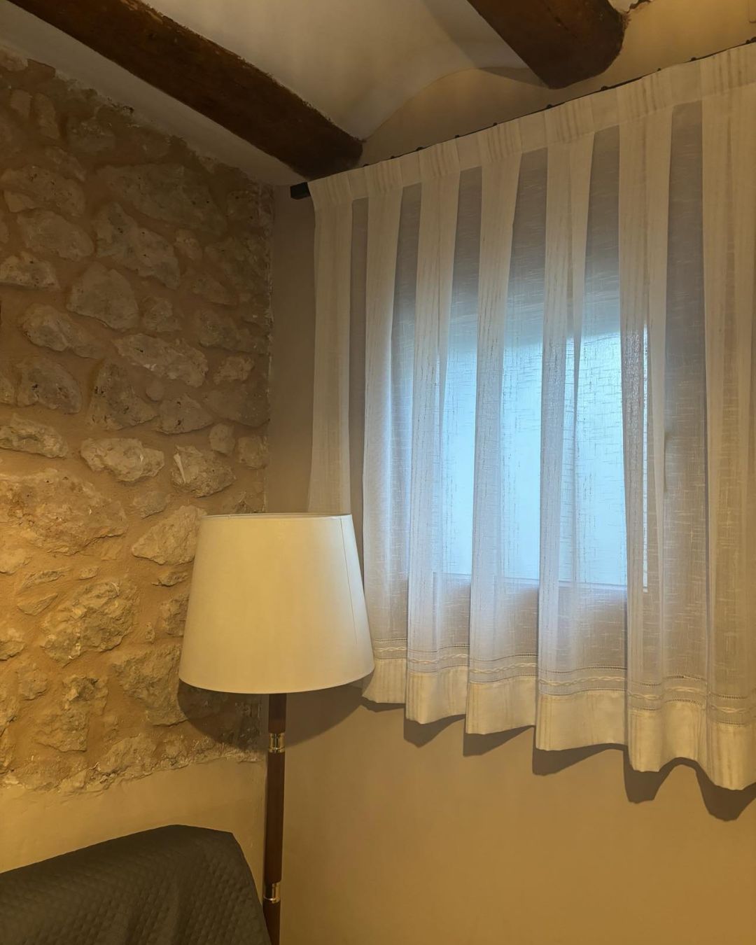 Cortina en primer plano con ventana entre abierta y persona en la calle