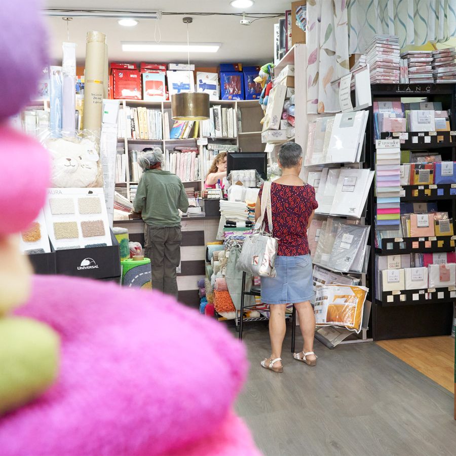 Vista de la tienda por dentro con todos los productos y clientas comprando
