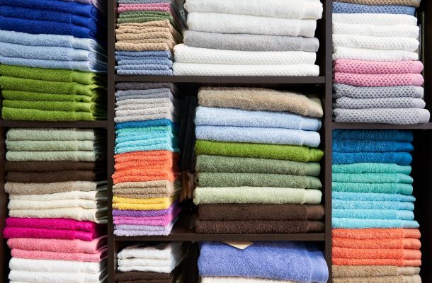 Imagen de estantería dentro de la tienda con toallas de colores 